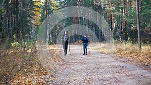 Young woman and a boy on scandinavian walk in the forest.