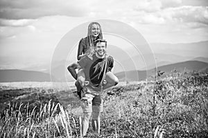 Young woman on boyfriend shoulders. Sensual portrait of young couple in love. Outdoor shot of man giving woman piggyback