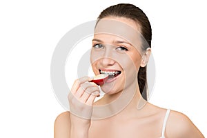 Young woman with brackets on teeth eating apple