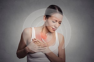 Young woman with breast pain touching chest photo