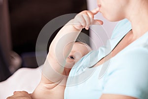 Young woman breastfeeding baby at home