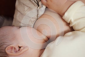 Young woman breastfeeding her baby at home close up