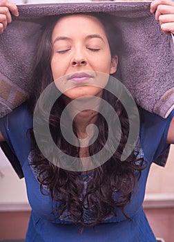 Young woman breathe very strong the steam around her, cleanning sessions of face traetment photo