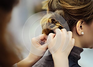 Young woman/bride getting her hair done before wedding or party