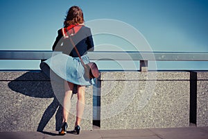 Young woman on bridge with skirt blowing