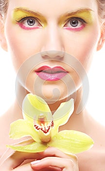 Young woman with bright make up holding orchid