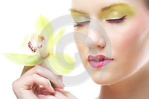 Young woman with bright make up holding orchid