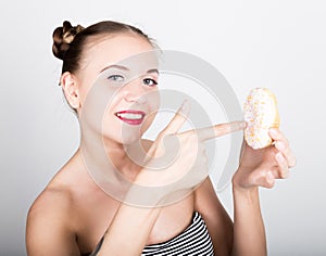 Young woman in bright makeup eating a tasty donut with icing. Funny joyful woman with sweets, dessert. dieting concept