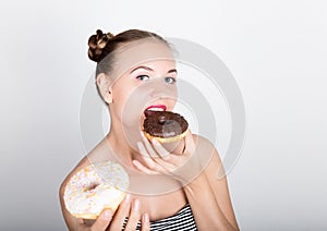 Young woman in bright makeup eating a tasty donut with icing. Funny joyful woman with sweets, dessert. dieting concept