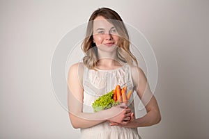 Young woman in a bright room holding a carrot