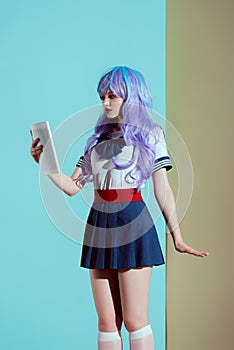 young woman in bright wig using digital tablet
