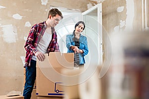 Young woman bringing open box moving in with her boyfriend