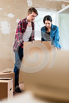 Young woman bringing open box moving in with her boyfriend into