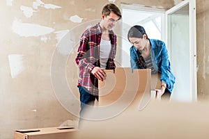 Young woman bringing open box moving in with her boyfriend into