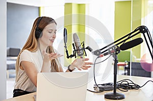 Young woman broadcasting in a studio gesturing, close up