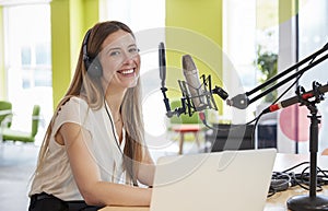 Young woman broadcasting in a studio smiling to camera