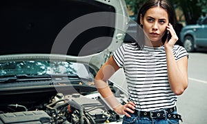 Young woman with a broken car