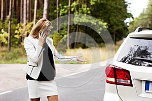 Young woman with broken car calling for help