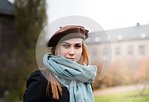 Young woman with brown beret and blue scarf