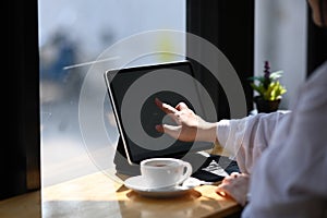 Close up view of young woman hand pointing on screen of tablet computer .