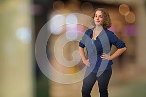 young woman brunette curly hair student standing in bokeh blur copy space background