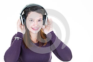 Young woman brunette with headphones looks in camera aside copy space