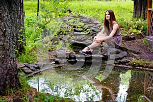 Young woman the brunette in the spring blossoming garden