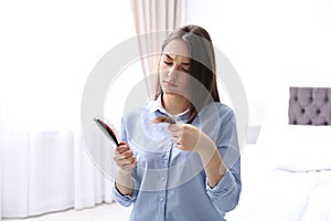 Young woman with brush indoors. Hair loss