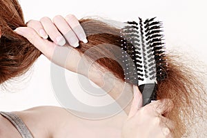 Young woman brushes her red hair