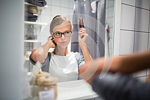 Young woman brushing healthy hair in front of a mirror