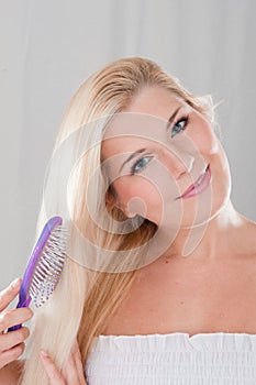 Young woman brushing her healthy hair