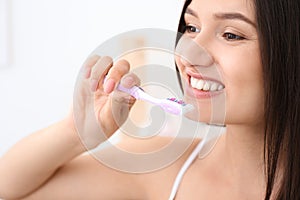 Young woman brushing her teeth in bathroom