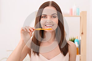 Young woman brushing her teeth in bathroom