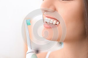 Young woman brushing her teeth in bathroom, closeup