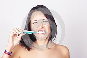 Young woman brushing her teeth isolated over white background