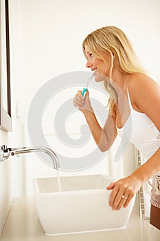 Young Woman Brushing Teeth In Bathroom