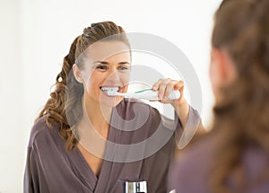 Young woman brushing teeth in bathroom