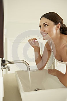 Young Woman Brushing Teeth In Bathroom