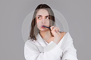 Young woman brushing teeth. Beautiful smile of young woman with healthy white teeth. Isolated gray background. Dental