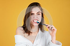 Young woman brushing teeth. Happy funny girl brush her teeth on isolated background. Beautiful wide smile of young woman