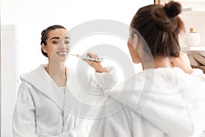 Young woman brushing teeth in morning