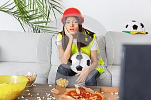 Young woman builder sport fan watching match bored