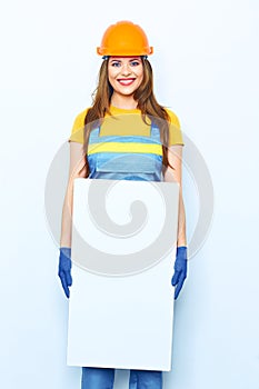 Young woman builder standing against white background with big