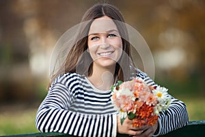 Young woman with bunch of wildflowers