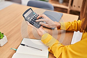 Young woman business worker using calculator at office