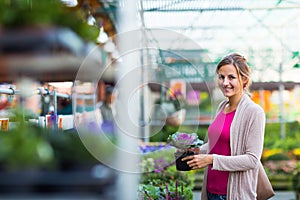 Young woman buying flowers at a garden center