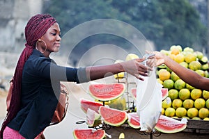 Young woman buying fruit.
