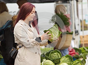 Young woman buying vegetables at the farmers market.