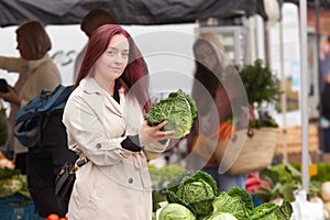 Young woman buying vegetables at the farmers market