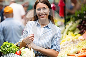 Young woman buying vegetables at the market.